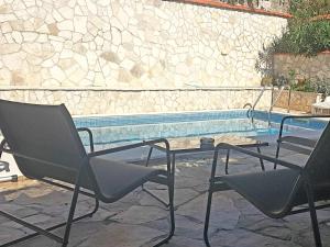 two chairs and a table next to a swimming pool at Villa Tina in Ploče