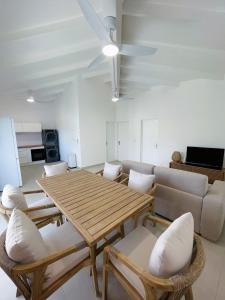 a living room with a wooden table and chairs at Emeraude Bay, Magnifique T3 Vue Mer proche de la plage in Le Gosier