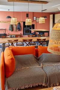 een oranje bank in een eetkamer met tafels bij La Breizhidence in Combourg