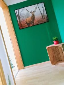 a green wall with a picture of a deer on it at Ferienwohnung Waldrausch in Baiersbronn