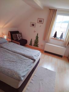 a bedroom with a bed and a window with christmas trees at Ferienwohnung Waldrausch in Baiersbronn