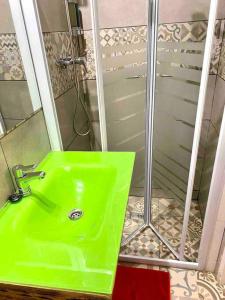 een groene wastafel in een badkamer met een douche bij L1 Estudio nuevo! Al lado del metro en Sants in Barcelona