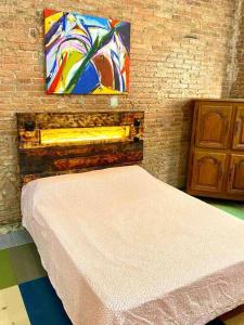 a bedroom with a bed with a painting on the wall at L1 Estudio nuevo! Al lado del metro en Sants in Barcelona