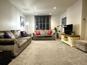 a living room with a couch and a television at Hudson Apartment - 2 bedroom, Oakham Centre by Belmont Places in Oakham