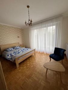a bedroom with a bed and a chair at maison bretonne 7 personnes in Mellac