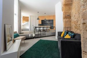 ein Wohnzimmer mit einem Sofa und einer Küche in der Unterkunft Be Local - Historic house of Santo André in Alfama - Lisbon in Lissabon