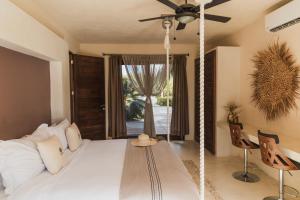 a bedroom with a swinging bed with a ceiling fan at Hotel Casa Punta Coco & Beach Club - Adults Only in Holbox Island