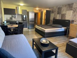 Una sala de estar con dos camas y una cocina. en Hotel "Mythos Apartments" alle Zimmer mit Kochnische, Apartments mit Küche!, en Markgröningen