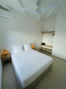 1 dormitorio blanco con 1 cama grande con sábanas blancas en Emeraude Bay, Magnifique T3 Vue Mer proche de la plage, en Le Gosier
