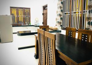 a dining room with a black table and chairs at Villa Exora Pasikudha in Batticaloa