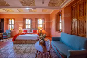 a bedroom with a bed and a couch and a table at Castle d'Atlas Riad & Spa in Marrakesh