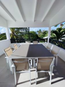 d'une table et de chaises blanches sur un balcon. dans l'établissement Emeraude Bay, Magnifique T3 Vue Mer proche de la plage, au Gosier