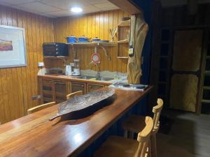 una cucina con bancone in legno e lavandino di Arte Vitral Lodge - 4camas- aislada- terrazas -vista - piscina-sauna a Guayacán