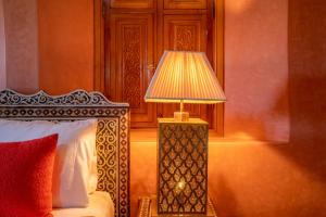 une lampe assise à côté d'un lit dans une pièce dans l'établissement Castle d'Atlas Riad & Spa, à Marrakech