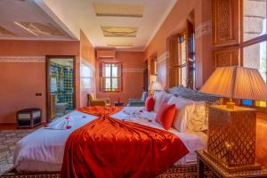 - une chambre avec un grand lit et des draps rouges dans l'établissement Castle d'Atlas Riad & Spa, à Marrakech