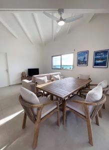 哥西爾的住宿－Emeraude Bay, Magnifique T3 Vue Mer proche de la plage，一间带木桌和椅子的用餐室
