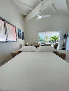 2 camas en una habitación con 2 ventanas en Emeraude Bay, Magnifique T3 Vue Mer proche de la plage en Le Gosier
