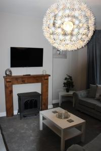 sala de estar con chimenea y lámpara de araña en Ashville Grange, en Scarborough