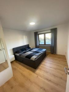 1 dormitorio con 1 cama grande en una habitación con ventana en Ferienwohnung Am Schillerfelsen Dahn, en Dahn
