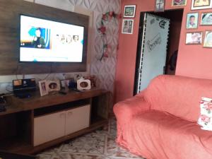 een woonkamer met een bank en een flatscreen-tv bij Casa de praia in Angra dos Reis