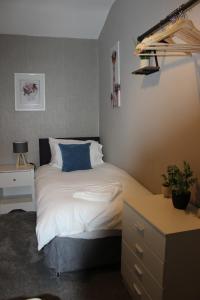 sypialnia z łóżkiem z niebieską poduszką w obiekcie Ashville Grange w Scarborough