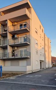 ein Apartmenthaus mit Balkon und einem Hydranten in der Unterkunft Apartman Metković City in Metković
