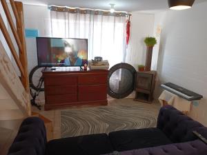 una sala de estar con TV de pantalla plana en una cómoda en Exelente casa completamente equipada., en Quintero