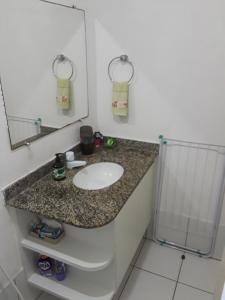y baño con lavabo y espejo. en Apart Itapua, en Salvador