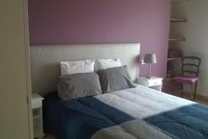 a bedroom with a bed with blue sheets and pillows at La route bleue in Ploumilliau