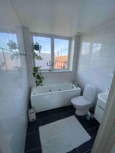 baño con bañera, aseo y ventana en Vackert boende med utsikt över fantastisk golfbana, en Brokind