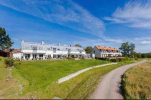 uma grande casa de campo branca com uma estrada de terra em Vackert boende med utsikt över fantastisk golfbana em Brokind