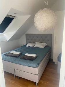 Un dormitorio con una cama con sábanas azules y una lámpara de araña. en Vackert boende med utsikt över fantastisk golfbana en Brokind