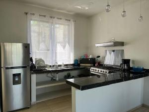 eine Küche mit Kühlschrank und Arbeitsplatte in der Unterkunft Departamento Marsopas a 5 minutos a pie de Bahía Carrizalillo!!! 6 in Puerto Escondido