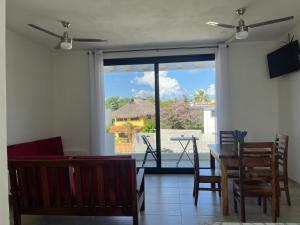 ein Wohnzimmer mit einem Tisch und Stühlen sowie einem großen Fenster in der Unterkunft Departamento Marsopas a 5 minutos a pie de Bahía Carrizalillo!!! 6 in Puerto Escondido