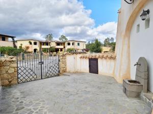 um portão em frente a uma casa com um edifício em Casa Mara em Cala Liberotto