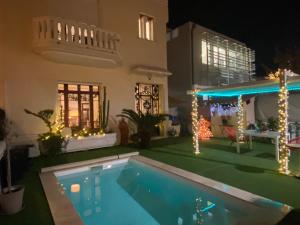 a swimming pool in front of a house with christmas lights at VILLA MARYSE avec piscine privative in Saint-Laurent-de-la-Salanque