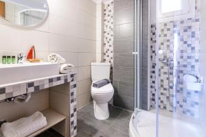 a bathroom with a toilet and a sink and a shower at Maria Rooms in Polychrono +48 photos