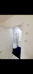 een badkamer met een witte deur en een wastafel bij Double ensuite room in Leicester