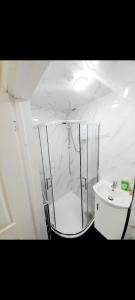 a white bathroom with a shower and a sink at Double ensuite room in Leicester