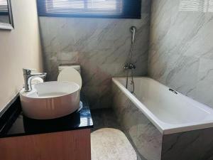uma casa de banho com um lavatório, uma banheira e um WC. em Kandembas nook em Lusaka