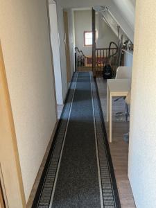 a hallway with a long black rug on the floor at Gästezimmer am Aartalsee in Bischoffen