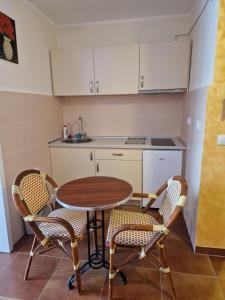 een kleine keuken met een tafel en 2 stoelen bij Apartmani Tina - Srebrno jezero in Zatonje