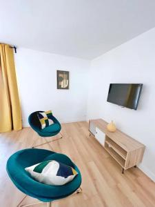 a living room with two chairs and a flat screen tv at Charming apartments 15 min away from Paris in Argenteuil