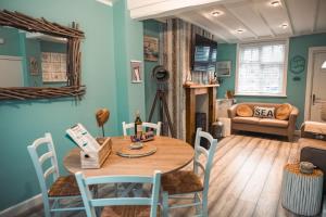 a dining room with a table and chairs at The Rambler's Rest Cottage, Parkgate, Wirral in Parkgate