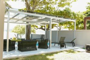 a pergola with chairs and a table on a patio at OPY CAMBOA in Governador Celso Ramos