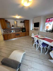 a kitchen with a table and chairs in a room at Trilocale con vista piste da sci in Villa Dalegno