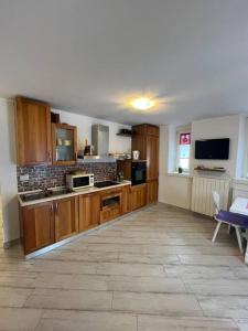 a large kitchen with wooden cabinets and a table at Trilocale con vista piste da sci in Villa Dalegno