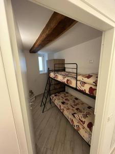 a small room with two bunk beds in it at Trilocale con vista piste da sci in Villa Dalegno