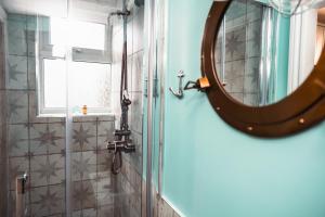 uma casa de banho com um espelho e um chuveiro em The Rambler's Rest Cottage, Parkgate, Wirral em Parkgate