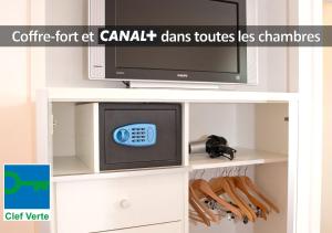 een tv in een kast met een magnetron en een televisie bij HÔTEL LA FERME DE BOURRAN - écoresponsable parking gratuit in Rodez